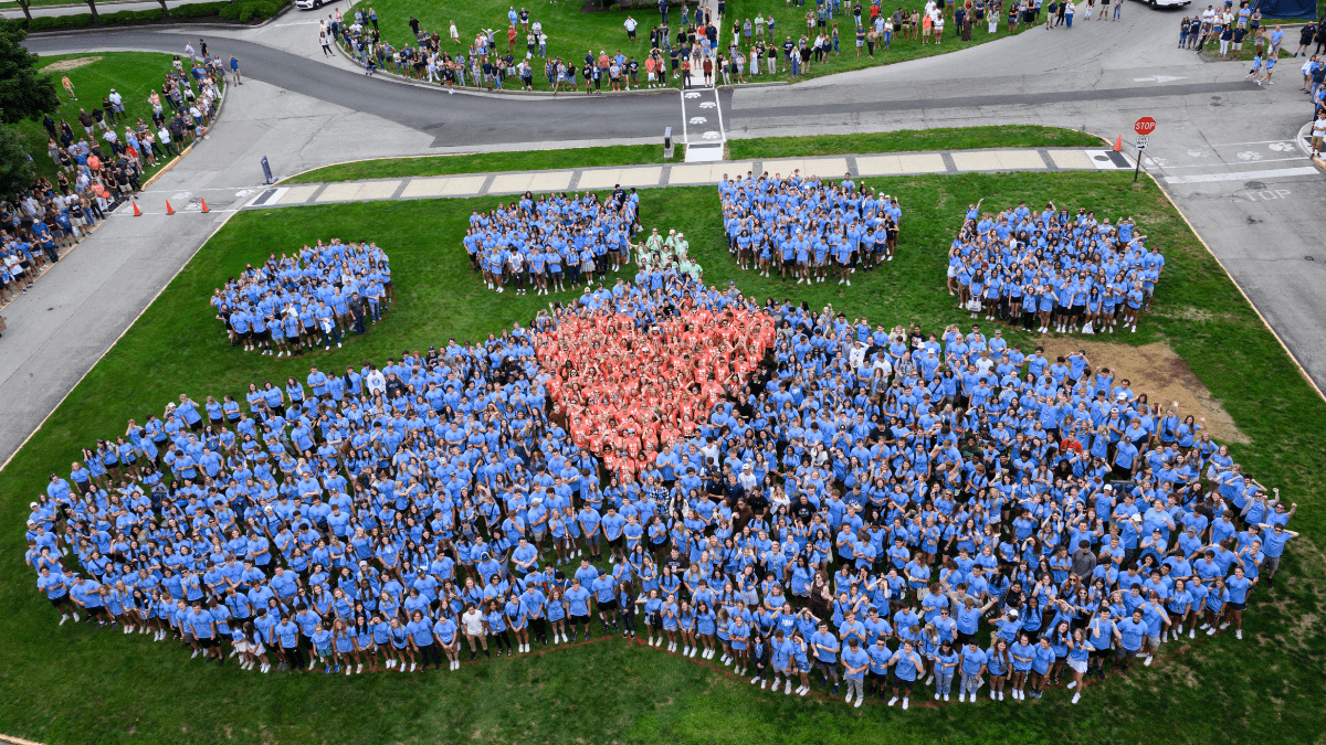 Group photo of new students in the shape of a paw print with a heart in the middle.